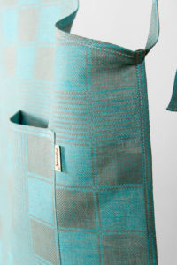 Linen apron in checked pattern, grey and light blue checks. Manufacturer: AB “Siulas”